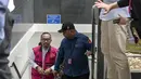 Mantan Direktur Utama PT Pertamina Patra Niaga, Riva Siahaan dijatuhi hukuman pidana penjara selama 9 tahun, ditambah denda sebesar Rp 1 miliar. Tampak dalam foto, mantan Direktur Utama PT Pertamina Patra Niaga, Riva Siahaan (kiri), dikawal menuju ke ruang sidang untuk mendengar pembacaan vonis oleh majelis hakim Pengadilan Tindak Pidana Korupsi, Jakarta, Kamis (26/2/2026). (BAY ISMOYO/AFP)