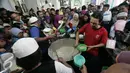 Pengurus masjid membagikan bubur kepada masyarakat di Masjid Darussalam,Solo, Selasa (7/6).Tradisi bubur Ramadan diselenggarakan dengan rata-rata 1100 porsi/hari. (Liputan6.com/Boy Harjanto)