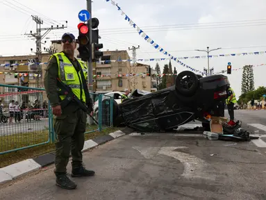 Polisi Israel menutup lokasi kecelakaan mobil, di mana menteri Israel Itamar Ben-Gvir dilaporkan terluka setelah mobilnya terlibat dalam kecelakaan, di Ramla, selatan Tel Aviv, Jumat (26/4/2024). (AHMAD GHARABLI / AFP)