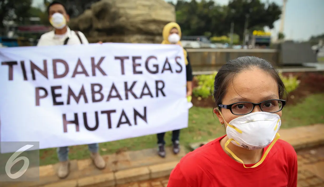 Seorang aktivis mengunakan masker saat aksi solidaritas #melawanasap di Patung Kuda kawasan Merdeka Barat, Jakarta, Jumat (9/10/2015). Aksi mendesak pemerintah beri pelayanan maksimal kepada seluruh korban kebakaran hutan. (Liputan6.com/Faizal Fanani)