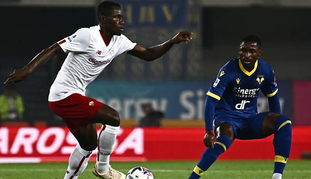 <p>Gelandang AS Roma, Mady Camara (kiri) mengontrol bola dari kawalan pemain Verona, Martin Hongla selama pertandingan lanjutan Liga Serie A Italia di stadion Marcantonio Bentegodi, di Verona, Italia, Senin 31 Oktober 2022. Berkat hasil ini, Roma sukses naik ke peringkat empat klasemen dengan perolehan poin 25. (AFP/MARCO BERTORELLO)</p>