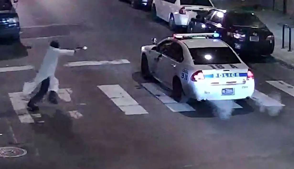 Sebuah gambar yang diambil dari rekaman video CCTV menunjukkan seorang pria bersenjata mendekati mobil polisi yang sedang berpatroli pada jam malam di Philadelphia, Pennsylvania, USA (8/1). (REUTERS/Philadelphia Police Department/Handout)