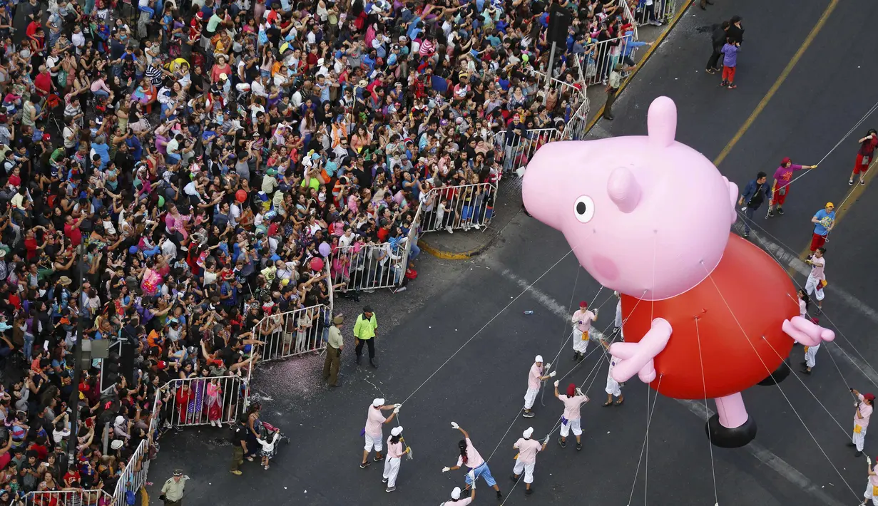 Parade balon karakter kartun meramaikan jalanan kota Santiago di Chile, (13/12). Selain parade balon ada juga parade kendaraan yang dihias unik. (REUTERS/Pablo Sanhueza)