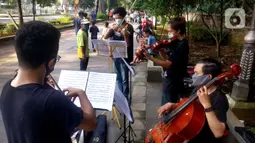 Musisi lokal Bogor memainkan musik klasik di pedestrian Kebun Raya, Jalan Pajajaran, Bogor, Jawa Barat, Minggu (14/6/2020). Untuk memenuhi kebutuhan hidup akibat sepinya job pertunjukan selama pandemi COVID-19, mereka memilih mengamen saat warga berolahraga. (merdeka.com/Arie Basuki)