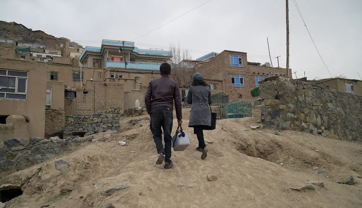 Petugas kesehatan mendatangi rumah penduduk di Kabul, Afghanistan, Senin (28/2). Polio tetap menjadi endemi di Afghanistan, Pakistan, dan Nigeria utara, meskipun sudah hampir hilang sepenuhnya di dunia. (AFP PHOTO / SHAH Marai)
