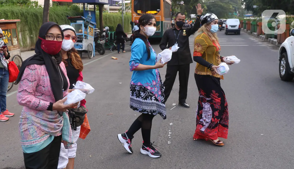 Sejumlah perempuan dengan mengenakan kebaya membagikan takjil untuk berbuka puasa bagi pengendara yang melintas di kawasan Tangerang, Banten, Rabu (21/4/2021). Pembagian takjil dengan mengenakan kebaya tersebut untuk merayakan Hari Kartini. (Liputan6.com/Angga Yuniar)