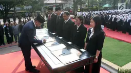 Gubernur DKI Jakarta Anies Baswedan menandatangani berkas saat melantik pejabat fungsional di halaman Balai Kota Jakarta DKI, Senin (4/6). Sebanyak 916 pejabat fungsional yang dilantik terdiri dari berbagai jenis pengangkatan. (Liputan6.com/Arya Manggala)