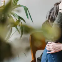Ilustrasi depresi, stres, social anxiety disorder. (Photo by Liza Summer: https://www.pexels.com/photo/unrecognizable-upset-lady-embracing-knees-sitting-on-chair-6382642/)