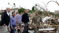 Presiden AS Donald Trump berkeliling ke permukiman warga yang rusak akibat terjangan Badai Maria di Guaynabo, Puerto Rico, Selasa (3/10). Trump menyaksikan langsung kehancuran akibat badai di Puerto Rico dan bertemu para pemimpin pulau itu (AP/Evan Vucci)