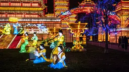 Pengunjung berdiri dekat lentera istana raksasa dalam Festival Lentera Gaillac di Taman Foucaud, Gaillac, Prancis, Rabu (12/12). Festival ini juga menandai berakhirnya perayaan untuk periode Tahun Baru China. (ERIC CABANIS/AFP)