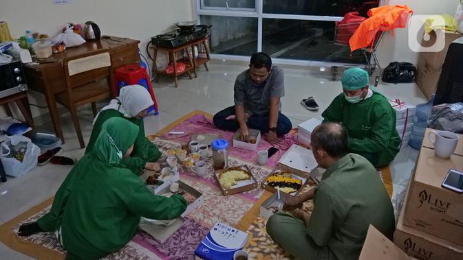 Para perawat berbuka puasa usai memeriksa pasien di Rumah Sakit Haji, Jakarta, Jumat (9/5/2020). Garda terdepan penanganan Covid-19 ini tetap menjalani bulan suci Ramadan di sela-sela menangani pasien terinfeksi dengan melakukan tadarus Quran dan buka puasa bersama. (Liputan6.com/Herman Zakharia)