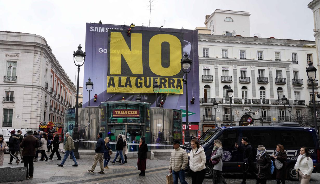 Perdana Menteri Spanyol Pedro Sanchez, Rabu (4/3/2026), dengan tegas menyatakan menolak tunduk terhadap eskalasi militer di Timur Tengah dan tetap menyerukan gencatan senjata segera antara Israel, Amerika Serikat (AS), dan Iran. Tampak dalam foto, para pejalan kaki berjalan saat para aktivis Greenpeace membentangkan spanduk besar bertuliskan "Tidak untuk Perang" sebagai bentuk protes terhadap serangan Amerika Serikat (AS) dan Israel terhadap Iran, di Lapangan Puerta del Sol, Madrid, Spanyol, pada Selasa 10 Maret 2026. (Paul Hanna/AFP)