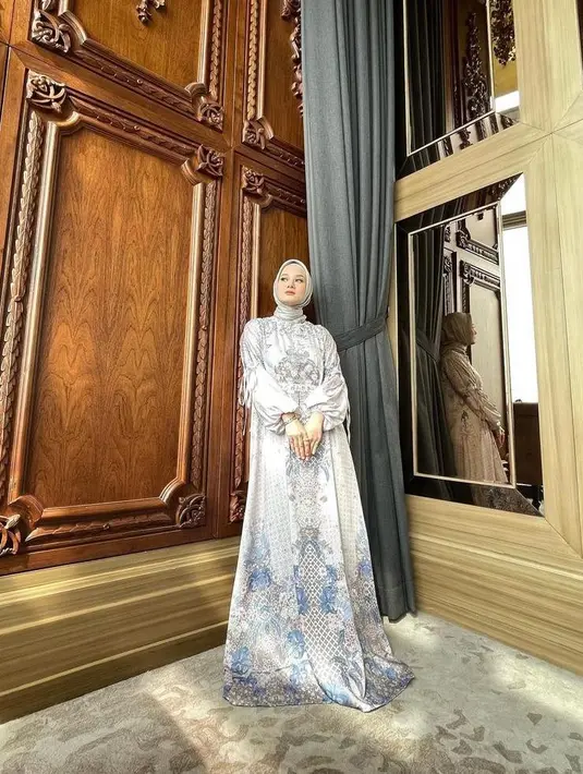 Solusi tampil mewah dan elegan di Hari Raya, kamu bisa memilih gamis bermotif dengan bahan silk seperti yang dikenakan Dinda Hauw ini. Padukan dengan hijab segi empat warna senada. (Instagram/dindahw).