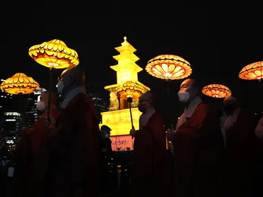 Biksu Buddha Korea Selatan mengenakan masker membawa lentera teratai berwarna-warni selama upacara pencahayaan untuk merayakan ulang tahun Buddha yang akan datang pada 8 Mei, di Seoul, Korea Selatan (5/4/2022). (AP Photo/Lee Jin-man)