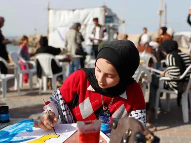 Para perempuan muda melukis di pelabuhan Kota Gaza pada Kamis 12 Februari 2026. Sejumlah aktivis perempuan menggelar Breath and Paint workshop atau lokakarya Bernapas dan Melukis. (Omar AL-QATTAA/AFP)