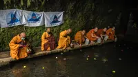 Para biksu mengambil air berkah di mata air Umbul Jumprit, Temanggung, untuk peringatan Waisak 2022 pada Minggu, 15 Mei 2022. (dok. JUNI KRISWANTO / AFP)