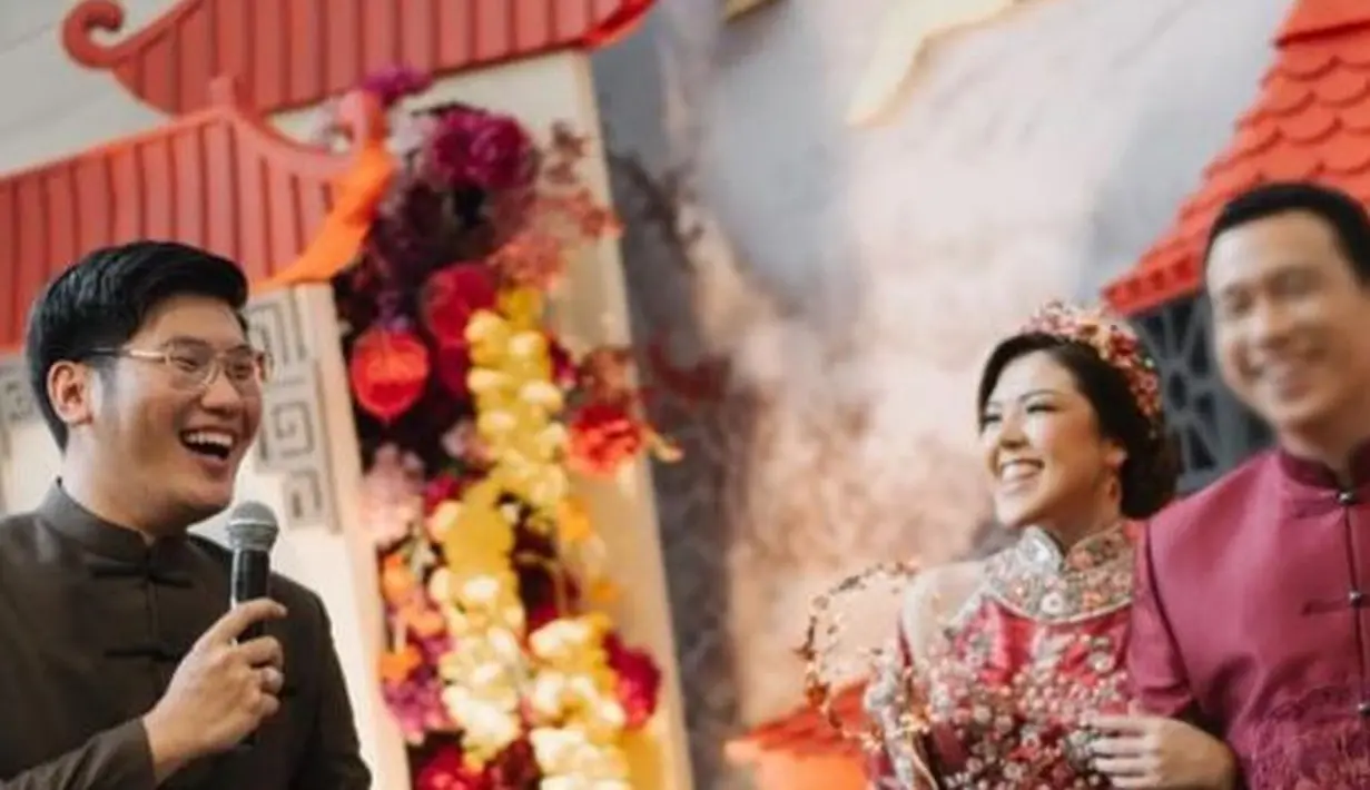 Sedangkan kekasihnya tampil lebih sederhana, bak raja kerajaan Cina. Mengenakan cheongsam merah dengan detail bordir di bagian tengah dan kancing-kancing yang unik. Foto: Instagram.