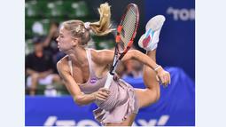 Petenis putri Italia, Camila Giorgi, saat melakukan servis ke arah petenis Serbia, Ana Ivanovic, dalam turnamen tenis Pan Pacific Terbuka di Tokyo, Jepang, Kamis (24/9/2015). (AFP Photo/Kazuhiro Nogi)