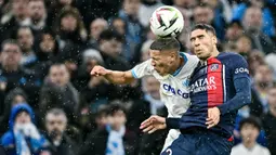 Pemain Paris Saint-Germain, Achraf Hakimi, duel udara dengan pemain Marseille, Amine Harit, dalam duel pekan ke-27 Ligue 1 2023/2024 di Stade Velodrome, Senin (1/4/2024). (AFP/Nicolas Tucat)