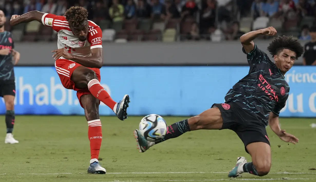 Striker Bayern Munchen, Kingsley Coman (kiri) melepaskan tendangan yang berusaha diblok bek Manchester City, Rico Lewis pada laga pramusim 2023/2024 bertajuk Audi Football Summit di Stadion Nasional Tokyo, Jepang, Rabu (26/7/2023) malam WIB. (AFP/Kazuhiro Nogi)
