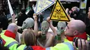 Sejumlah demonstran menggunakan masker gas saat unjuk rasa menolak London Fashion Week, Inggris (19/2). Para wanita ini bertelanjang saat melakukan aksi demo. (REUTERS / Neil Balai)