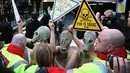 Sejumlah demonstran menggunakan masker gas saat unjuk rasa menolak London Fashion Week, Inggris (19/2). Para wanita ini bertelanjang saat melakukan aksi demo. (REUTERS / Neil Balai)