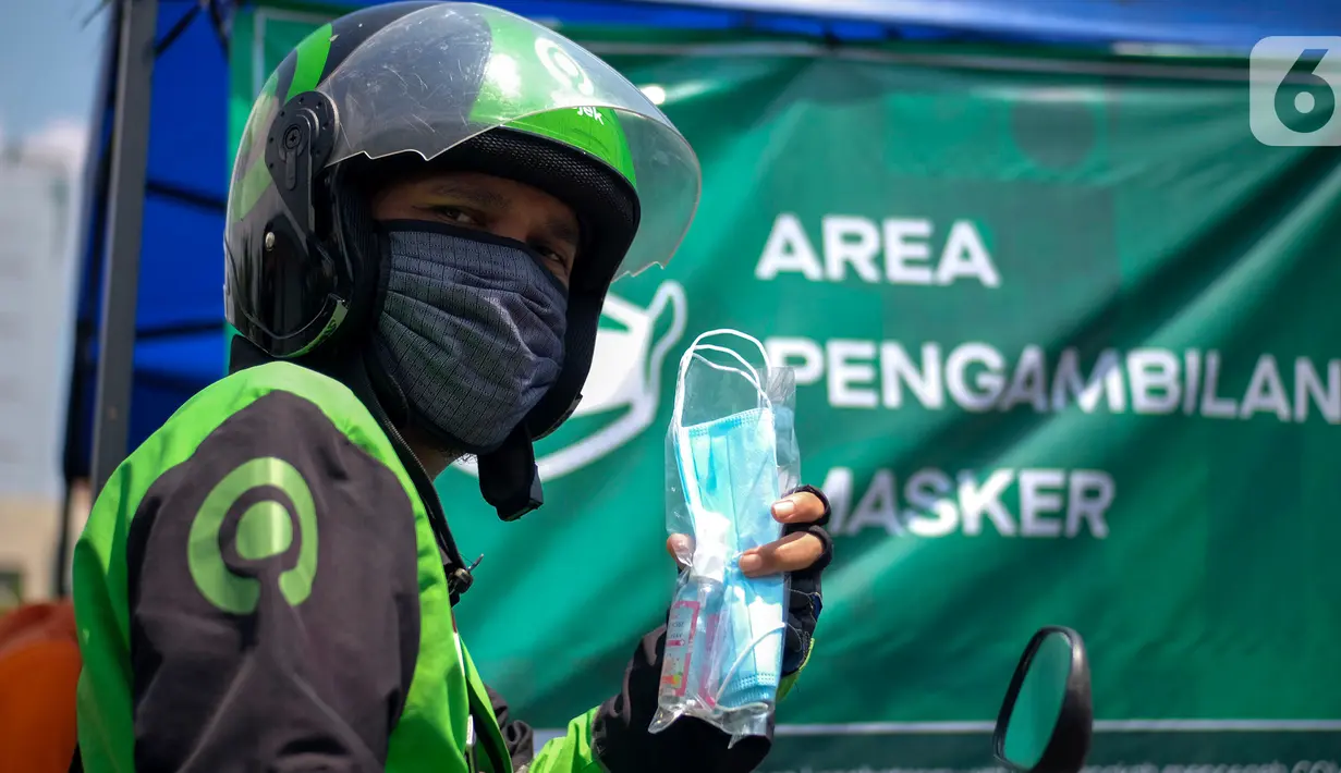 Mitra Gojek saat menerima masker di Posko Aman Bersama Gojek, Kemayoran, Jakarta, Kamis (23/4/2020). Posko Gojek menerapkan drive thru dengan 3 jenis layanan mulai dari pembagian healthy kit, pengecekan suhu tubuh dan penyemprotan cairan disinfektan untuk kendaraan. (Liputan6.com/HO/Ading)