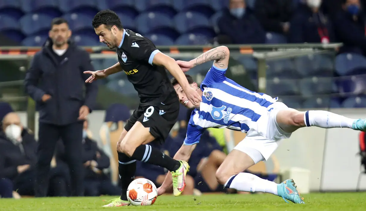 Pemain Lazio Pedro (kiri) berlari dengan bola menjauhi pemain Porto Mateus Uribe pada pertandingan Liga Europa di Stadion Dragao, Porto, Portugal, 17 Februari 2022. Porto menang 2-1. (AP Photo/Luis Vieira)