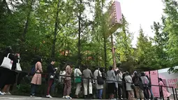 Penggemar mengantre untuk memasuki toko pop-up BTS di Distrik Gangnam, Seoul, Korea Selatan, Jumat (18/10/2019). House of BTS merupakan sebuah pop-up store versi lebih besar dibandingkan yang selama ini dibuka di lokasi konser BTS. (Jung Yeon-je/AFP)