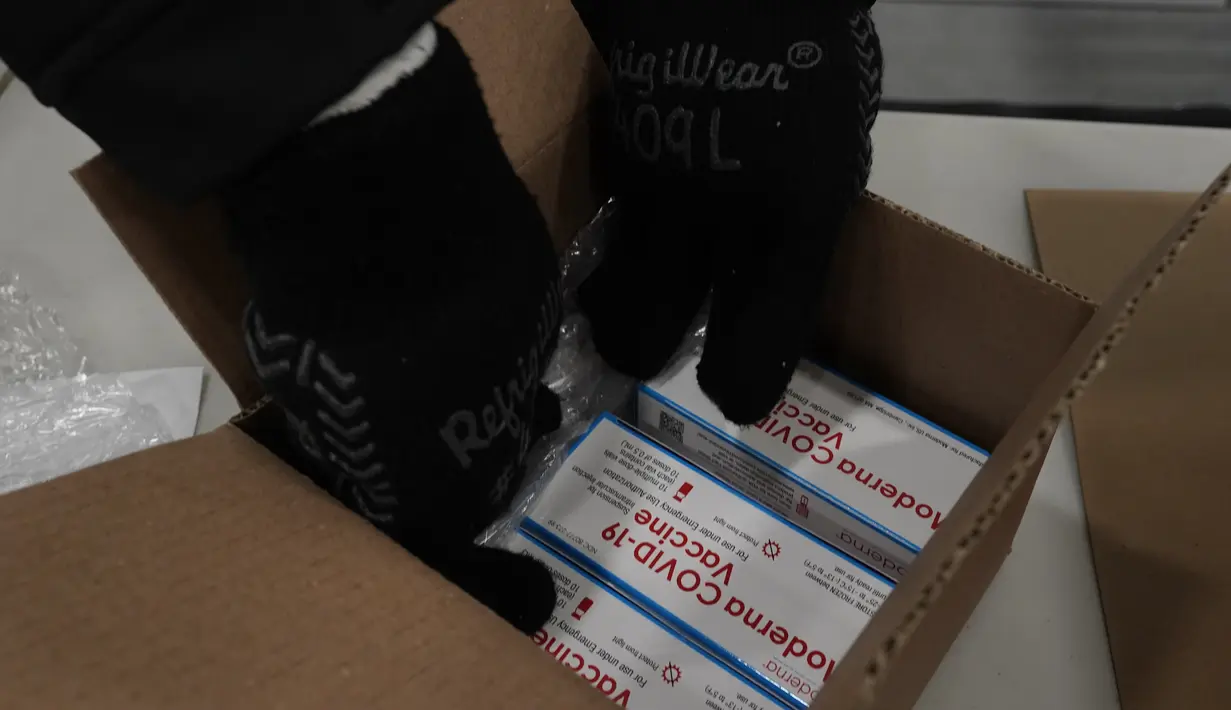 Pekerja mengemas box berisi vaksin Moderna COVID-19 untuk pengiriman di pusat distribusi McKesson di Olive Branch, Mississippi, AS, Minggu (20/12/2020). Pemerintah federal berencana selama seminggu mendistribusikan total 7,9 juta dosis vaksin dari Moderna dan Pfizer Inc. (AP Photo/Paul Sancya, Pool)