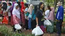 Dua wanita membawa paket sembako murah yang dijual oleh PT Asabri (Persero) di RPTRA Alur Dahlia, Tegal Alur, Jakarta Barat, Selasa (21/5/2019). Asabri menjual sebanyak 3 ribu sembako seharga Rp 10 ribu kepada masyarakat sekitar. (Liputan6.com/Johan Tallo)