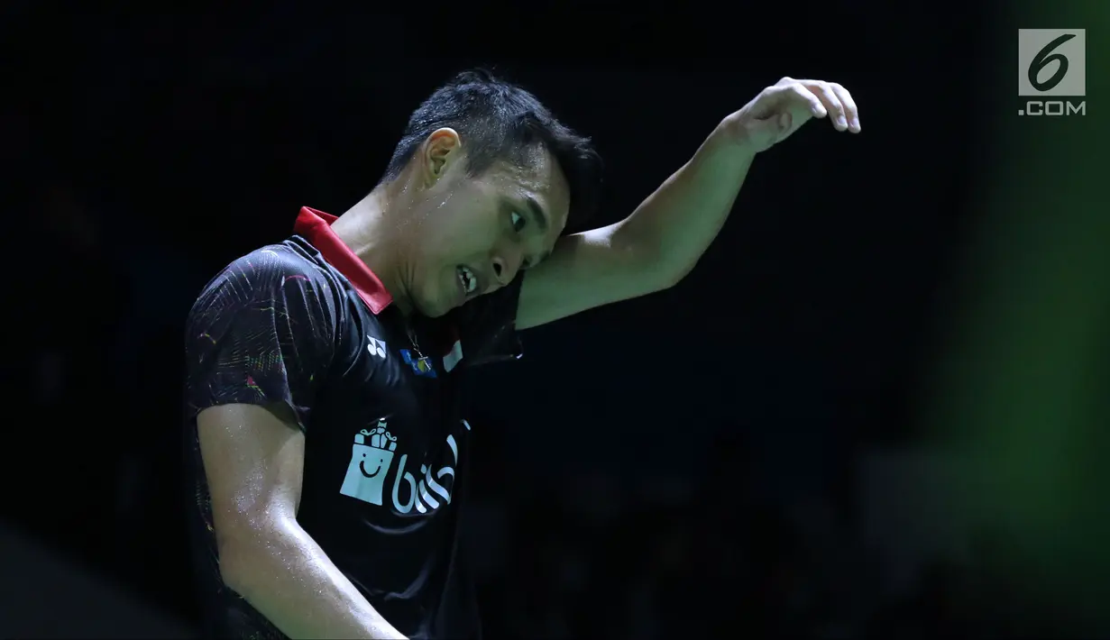 Tunggal putra Indonesia Jonatan Christie mengelap wajah saat melawan pebulutangkis Denmark, Viktor Axelsen pada babak pertama Indonesia Open 2018 di Istora GBK, Jakarta, Selasa (3/7). Jonatan kalah 10-21, 19-21. (Liputan6.com/Helmi Fithriansyah)
