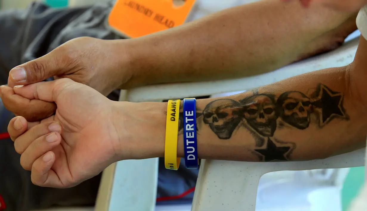 Seorang pasien rehabilitasi memakai gelang bertuliskan nama Presiden Filipina Duterte saat menjalani kegiatan rutinnya di Pusat Pemulihan Kristen di Antipolo, Filipina (12/9). (REUTERS/Romeo Ranoco)
