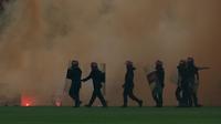 Pihak keamanan masuk ke lapangan setelah pendukung Malaysia melempar suar dan kembang api ke lapangan saat pertandingan Malaysia melawan Arab Saudi saat Kualifikasi Piala Dunia 2018 di Malaysia, Selasa (8/9/2015). (Reuters)