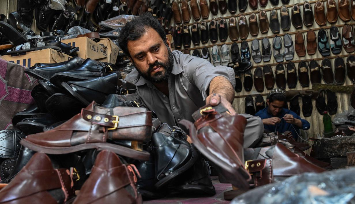 Khussa merupakan alas kaki tradisional kulit buatan tangan yang berasal dari Asia Selatan yang cukup popular khususnya di Pakistan. Tampak dalam foto, aktivitas seorang pembuat sepatu membuat khussa, alas kaki tradisional, di sebuah bengkel menjelang perayaan Idul Fitri selama bulan suci Ramadan 1447 Hijriah di Lahore pada 14 Maret 2026. (Arif ALI/AFP)