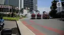 Petugas Dinas Pemadam Kebakaran Pemprov DKI melakukan penyemprotan cairan disinfektan di Jalan Thamrin, Jakarta, Selasa (31/3/2020). Penyemprotan yang dilakukan terus menerus itu untuk meminimalisir penyebaran COVID-19 di ruang udara dan ruas jalan. (Liputan6.com/Faizal Fanani)