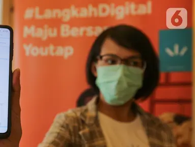 Model menunjukkan grafik cash flow pada aplikasi Youtap di coffe shop, Gading Serpong, Tangsel, Sabtu (14/11/2020). Youtap mendorong penggunaan pembayaran non-tunai kepada pelaku usaha demi memberi transaksi yang lebih higienis di tengah pandemi Covid-19. (Liputan6.com/Fery Pradolo)