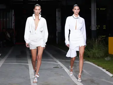 Model Bella Hadid dan Kendall Jenner berjalan di atas catwalk memakai busana Off White Spring/Summer 2019 selama Paris Fashion Week, Prancis (27/9). Kedua model tersebut tampil cantik membawakan koleksi rancangan Virgil Abloh. (AP Photo/Thibault Camus)