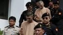 Dua tersangka pemboman Yusufu Mieraili dan Bilal Mohammed berjalan dikawal petugas saat meninggalkan Pengadilan militer (24/11). Pengadilan Thailand telah mendakwa dua orang yang dituduh melakukan serangan bom di Bangkok. (REUTERS /Chaiwat Subprasom)