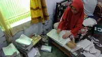 Aktivitas Titi Warga Desa Ciherang Kabupaten Kuningan melipat kertas untuk dijadikan bungkus gorengan. Foto (Istimewa)