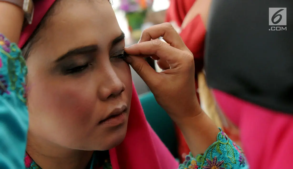 Peserta memasang bulu mata dengan tanpa melihat di Kantor Balai Kota Tangerang Selatan, Banten, Jumat (27/4). Lomba merias wajah dengan mata tertutup bertujuan meningkatkan kualitas hidup perempuan. (Merdeka.com/Arie Basuki)