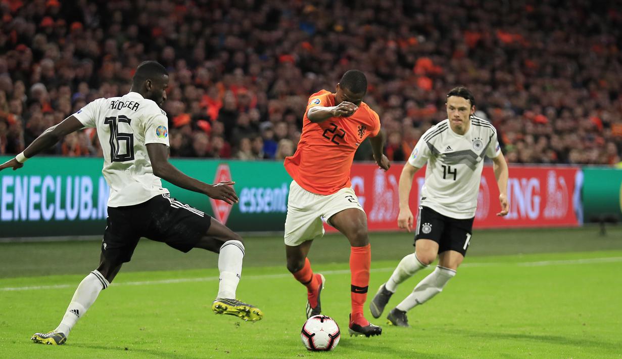 Pemain Belanda, Denzel Dumfries, berusaha melewati bek Jerman, Antonio Rudiger, pada laga kualifikasi Piala Eropa di Stadion Johan Cruyff, Minggu (24/3). Belanda takluk 2-3 dari Jerman. (AP/Peter Dejong)