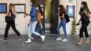 Para siswa mengikuti sejumlah tanda petunjuk yang dipasang di lantai saat berjalan di sebuah sekolah menengah atas di Roma, Italia (14/9/2020). Jutaan siswa di Italia kembali bersekolah pada Senin (14/9). (Xinhua/Elisa Lingria)