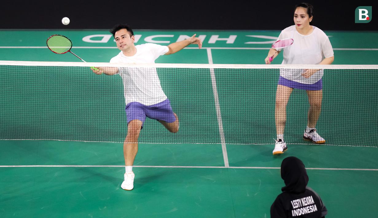Pasangan selebritas Raffi Ahmad dan Nagita Slavina berusaha mengembalikan kok saat bertanding melawan pasangan Rizky Billar dan Lesti Kejora pada laga bulu tangkis ganda campuran Turnamen Olahraga Selebriti Indonesia (TOSI) di GOR UNJ, Jakarta, Minggu (16/07/2023). Raffi dan Gigi kalah dua set langsung dari Rizky Billar dan Lesti dengan skor 12-21, 10-21.(Bola.com/Bagaskara Lazuardi)