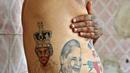 Guinness Rishi menunjukan tato bergambar seorang ratu di tubuhnya di New Delhi, India (20/5). Guinness Rishi merupakan pemegang rekor dunia yang paling banyak menato bendera negara dari seluruh dunia. (REUTERS/Cathal McNaughton)