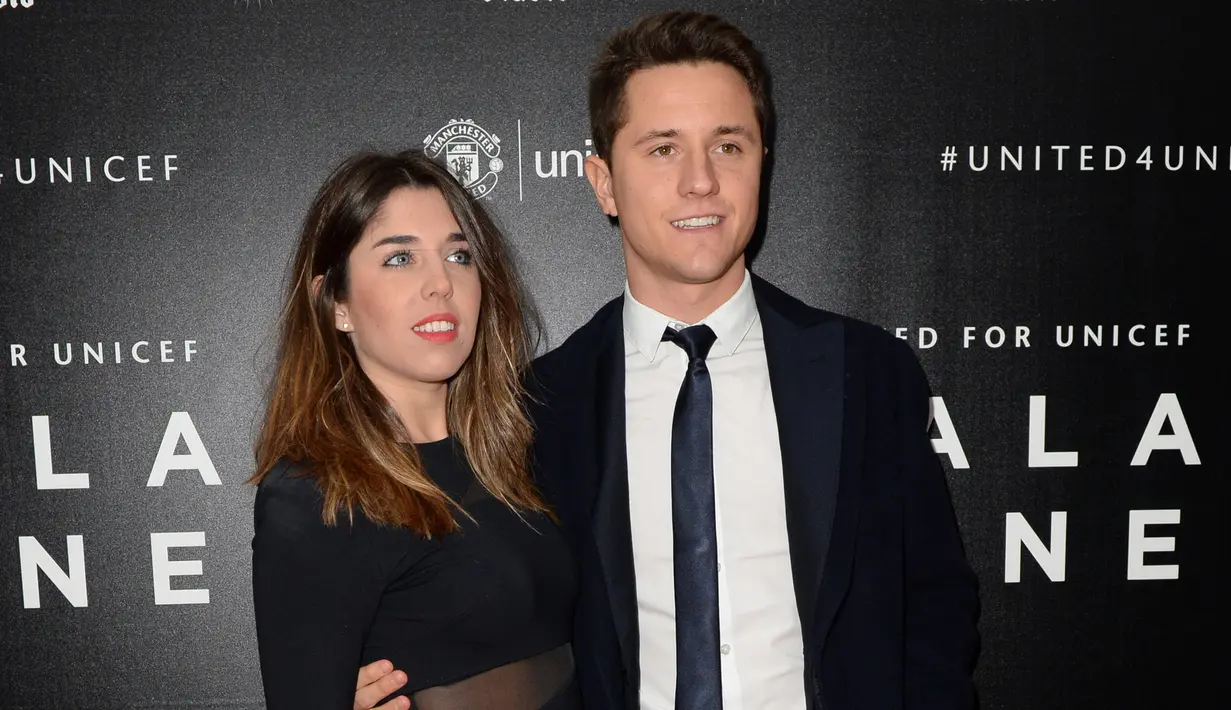 Gelandang Manchester United, Ander Herrera (kanan) dan pacarnya Isabel Collado berpose di atas karpet merah saat mereka tiba untuk menghadiri "Inggris untuk UNICEF Gala Dinner" di Old Trafford, Manchester, Inggris, (29/11). (AFP PHOTO/OLI SCARFF)