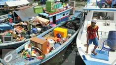 Seorang anak berada di atas kapal saat rumahnya mulai dihancurkan oleh alat berat petugas, Jakarta, Senin (11/4). Pemprov DKI membongkar ratusan rumah di wilayah Pasar Ikan. (Liputan6.com/Yoppy Renato)