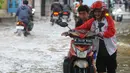 Pengendara mendorong motornya melintasi banjir di Jalan Benteng,  Duta Kranji, Kalibaru, Bekasi, Jawa Barat, Jumat (24/2/2023). Hujan yang turun di Bekasi sejak Kamis malam mengakibatkan sejumlah wilayah di Bekasi tergenang hingga lebih dari 50 cm. (merdeka.com/Imam Buhori)