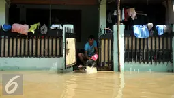 Seorang warga saat menguras air akibat banjir di komplek Polri jalan Pondok Karya, Mampang, Jakarta, Kamis (21/4). Banjir setinggi 120cm disebabkan meluapnya Kali Mampang. (Liputan6.com/Gempur M Surya)