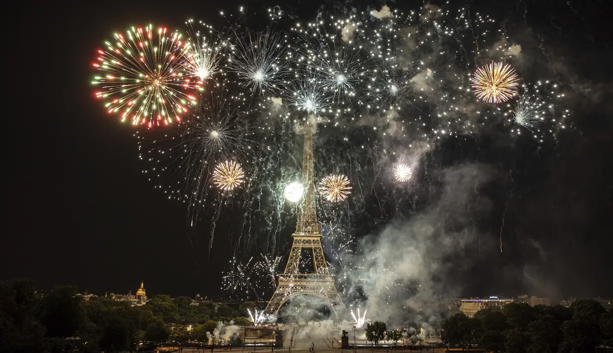 Kembang api menerangi Menara Eiffel selama perayaan Hari Bastille di Paris, Kamis (14/7/2022) malam. Penyerbuan penjara Bastille dipandang sebagai simbol pemberontakan bangsa dan rekonsiliasi seluruh rakyat Prancis. (AP Photo/Lewis Joly)
